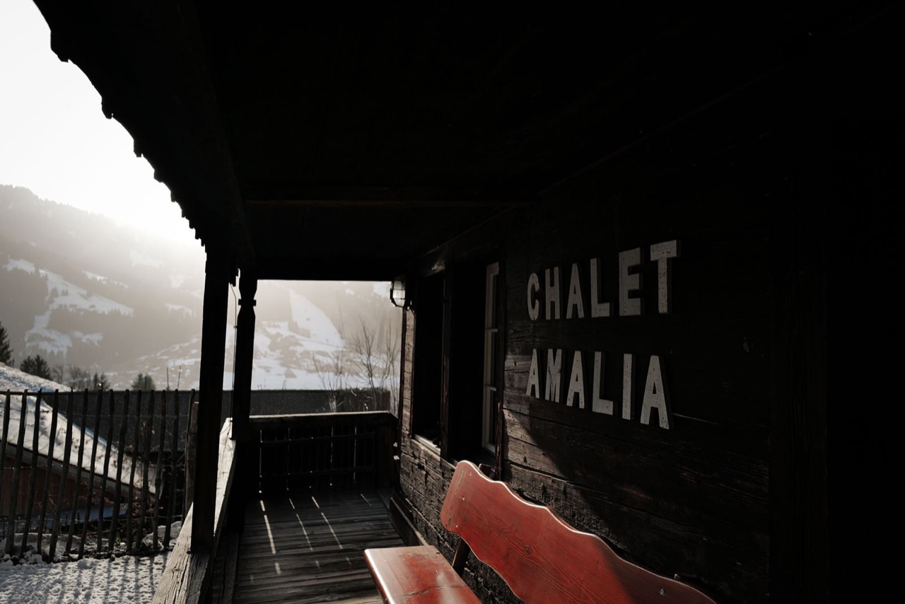 Chalet Amalia covered terrace in winter with name sign and snowy Lenk valley view