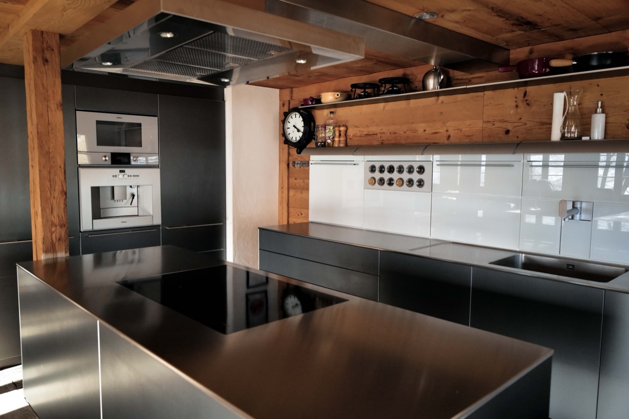 Modern kitchen with stainless steel island and timber beams