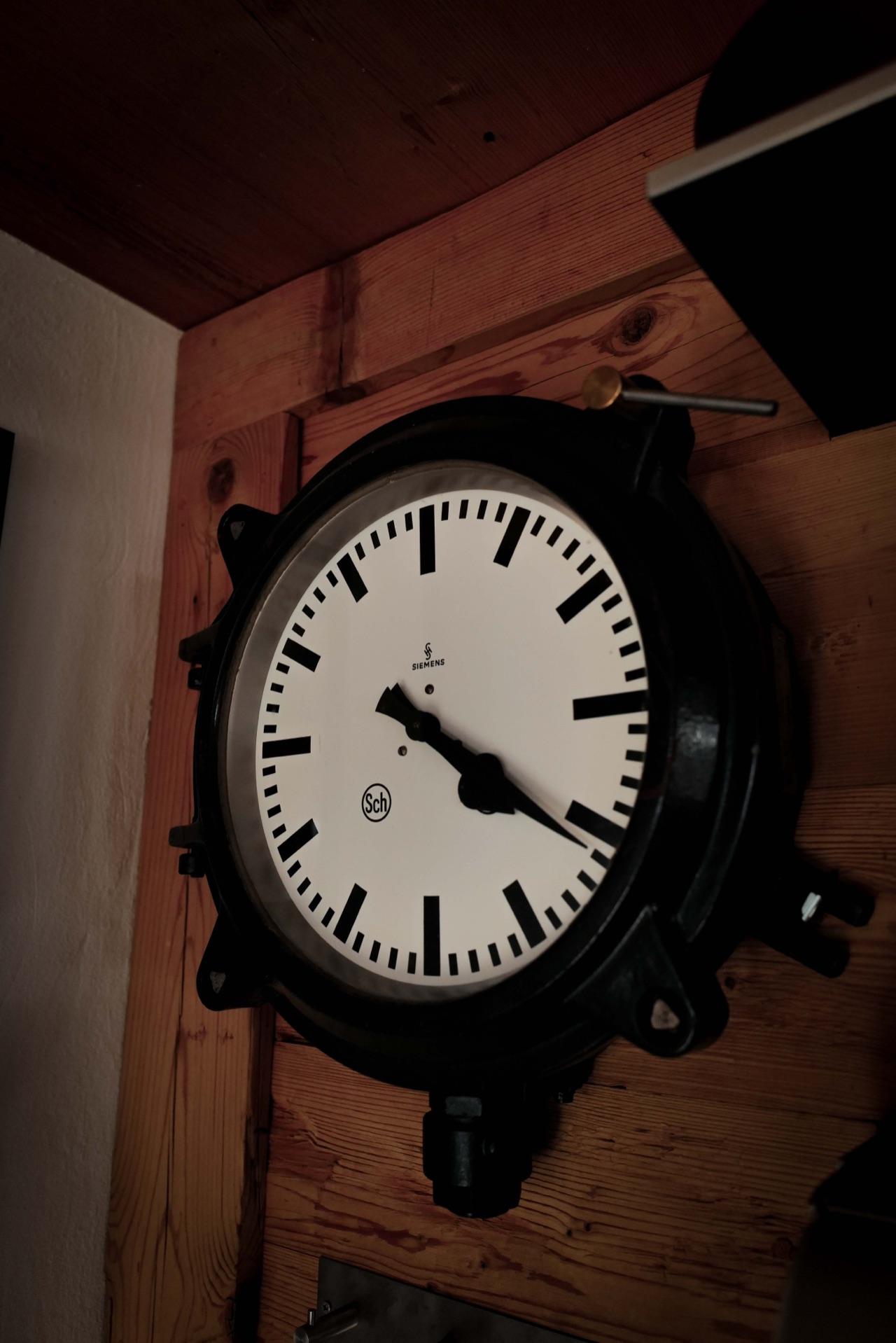 Vintage Siemens station clock on warm timber wall