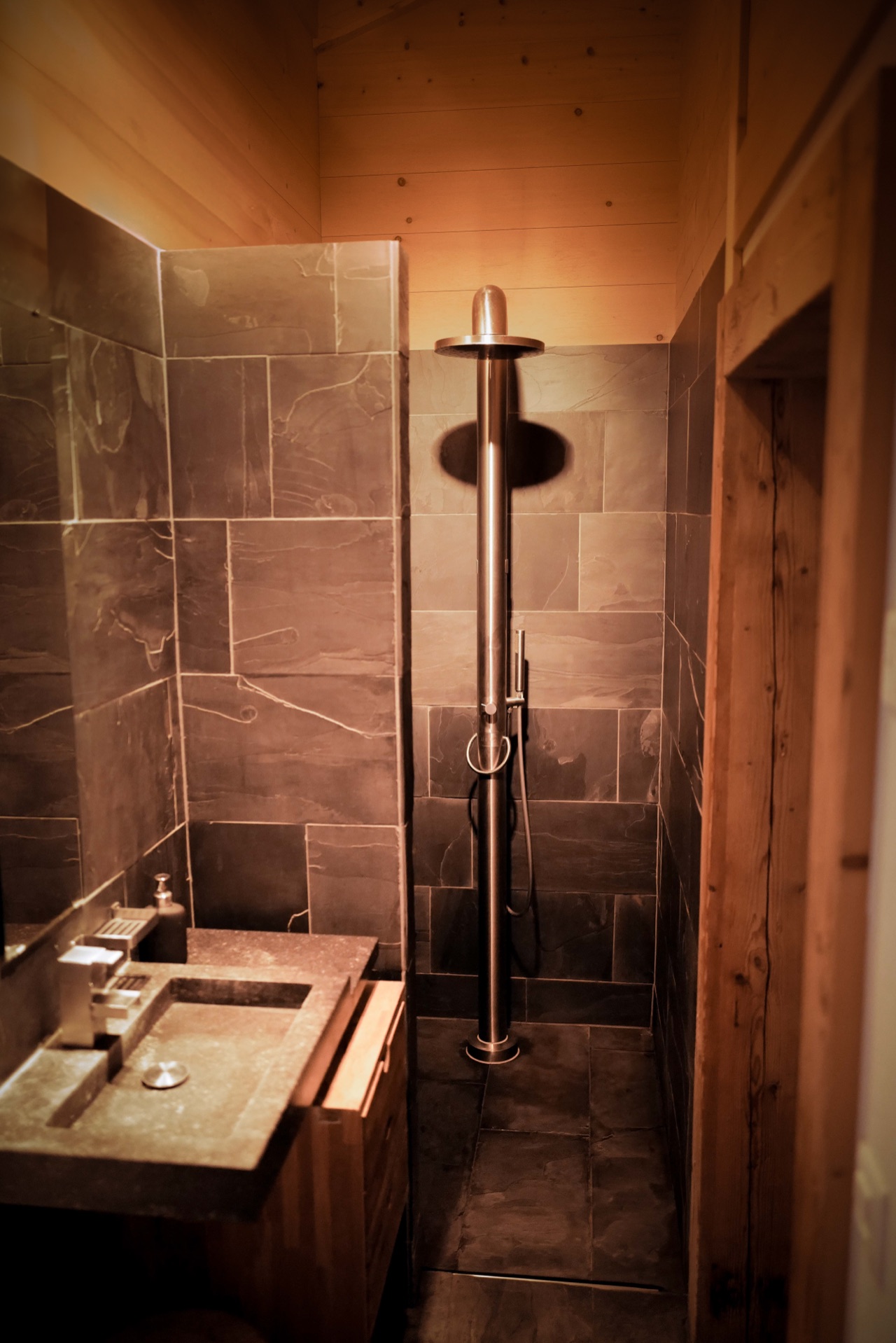 Walk-in rain shower with natural slate tiles and timber ceiling