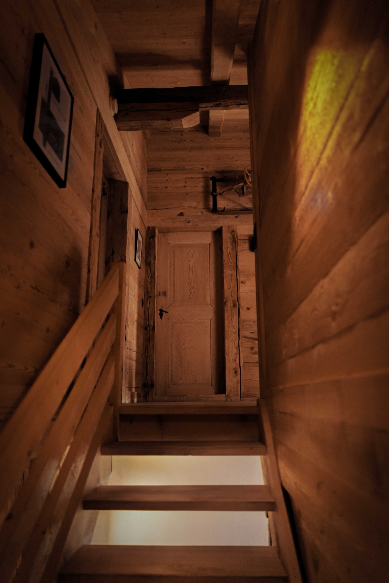 Original timber staircase looking upward with warm light filtering through