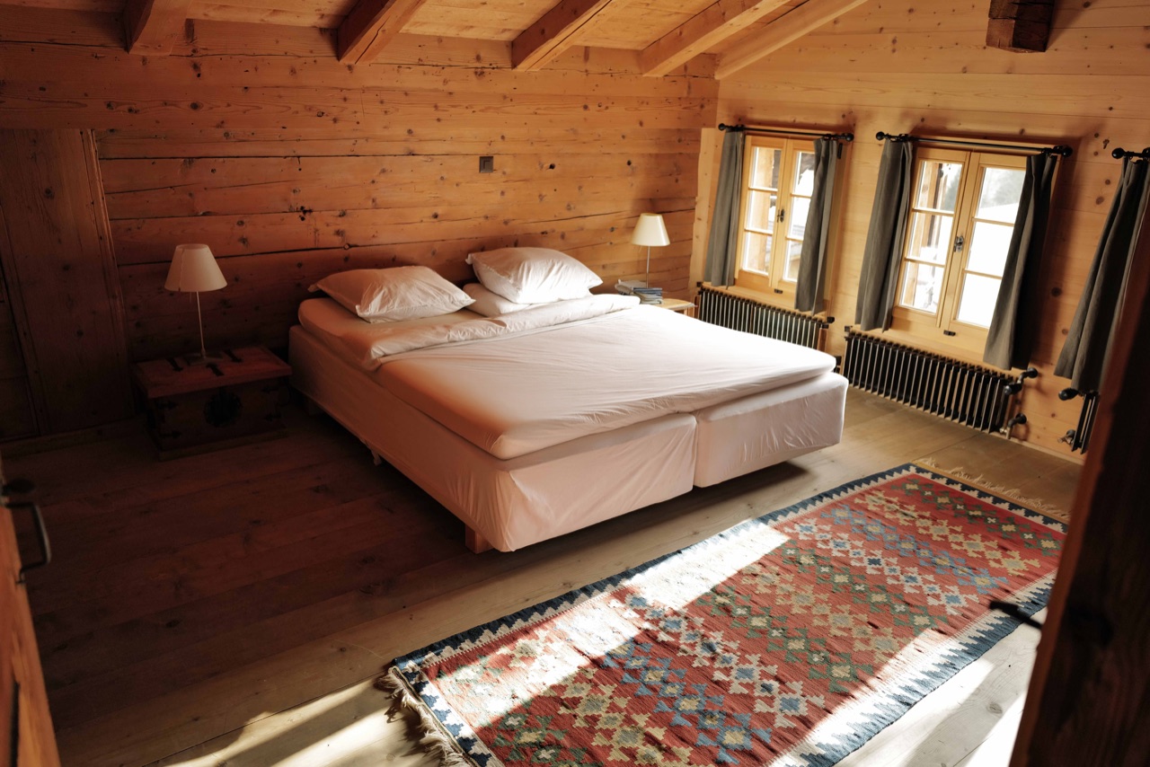 Main bedroom with double bed, kilim rug and exposed timber beams