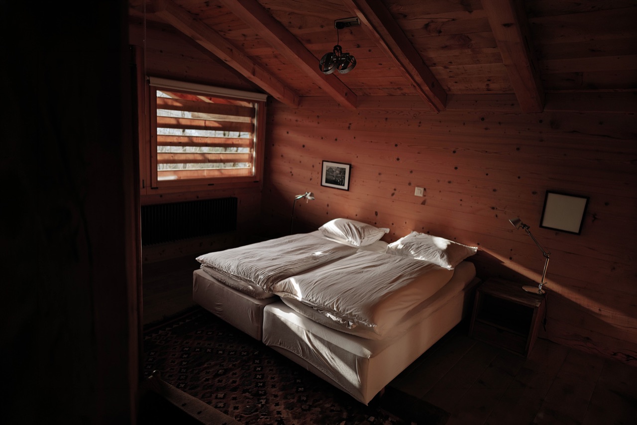 Double bedroom under the eaves with dappled light through shutters